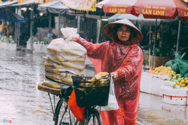 Người phụ nữ bán hàng rong dưới mưa. Ảnh: Việt Hùng. 