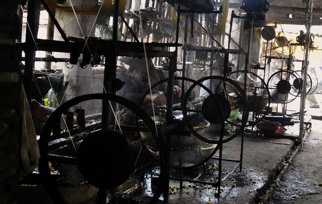 Trong những xưởng kéo tơ, các bà các chị miệt mài làm việc trong màn khói bốc nghi ngút từ nồi nước luộc kén. 