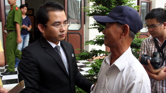 Luật sư Phạm Hoài Nam an ủi cha của bị cáo Minh sau khi tòa tuyên án - Ảnh: Đức Tuyên 