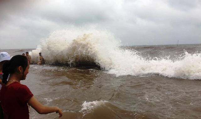 Những cơn sóng mạnh liên tiếp tấp vào bờ đê, ảnh hưởng đến việc lưu thông xe cộ và kinh doanh của các tiểu thương tại biển Quất Lâm 
