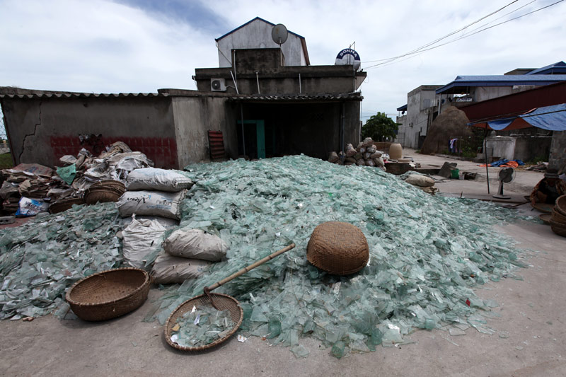 Mảnh kính vỡ được gia đình anh Phạm Ngọc Hân, chủ một lò thổi thủy tinh ở làng Xối Trì chất thành đống lớn giữa sân nhà 