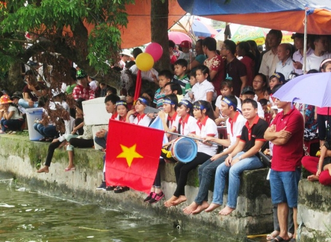 Những cổ động viên ngồi đông kín bên bờ sông để cổ vũ cho những đội thi.