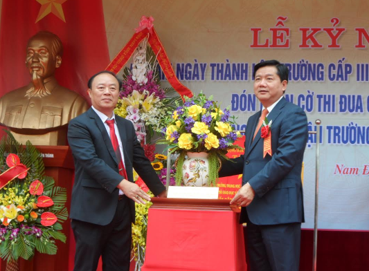 Ông Đinh La Thăng, Ủy viên Bộ Chính trị, Bí thư Thành ủy thành phố Hồ Chí Minh trao tặng Trường THPT Ngô Quyền lẵng hoa tươi thắm.
