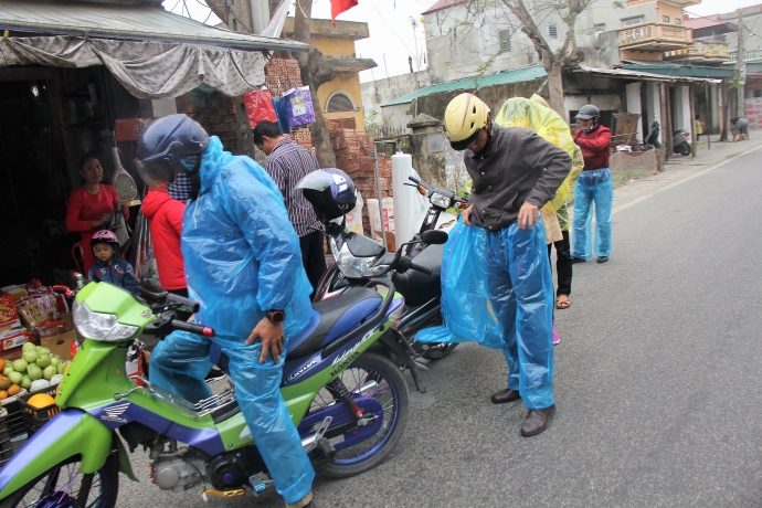 Nhiều người dân phải ghé hàng tạp hóa trên đường vào hội chợ Viềng để mua áo mưa tiếp tục hành trình